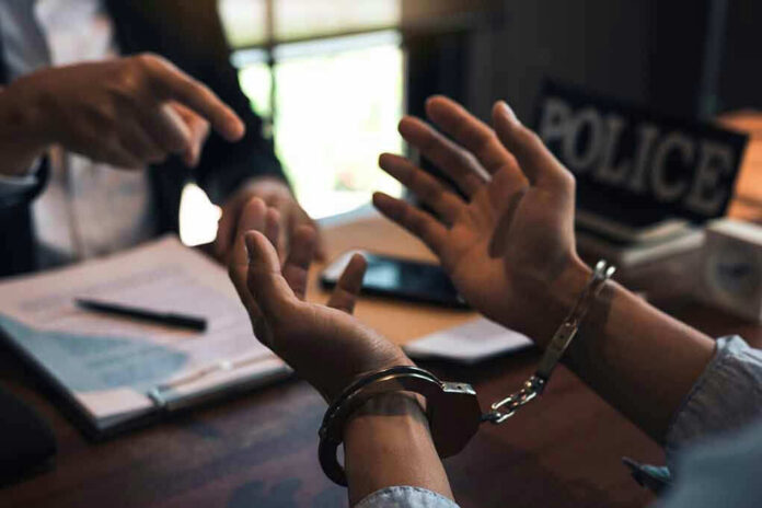 1669066165 Person handcuffed in discussion with another person