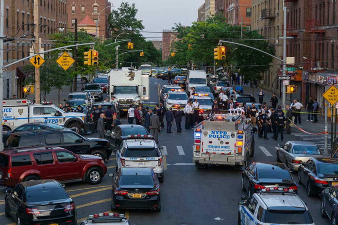 1976471648 Police activity on a city street with emergency vehicles.