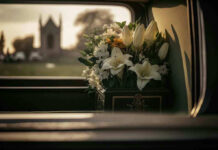 Legendary Director DEAD – Hollywood Stunned! White flowers in a car with blurred background.