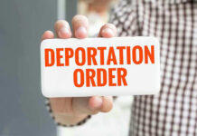 ICE Nabs Veteran’s Wife During Routine Check-In! Hand holding sign with Deportation Order text.