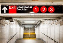 Subway exit sign indicating Downtown and Brooklyn with train numbers 1, 2, and 3