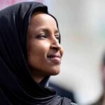 Half Of All Migrants In MN Have Committed Immigration Fraud! Woman wearing a black hijab looking thoughtfully into the distance