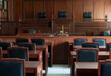 Serial Rapist ARRESTED – 20 Years Later! Empty courtroom with wooden furnishings and judges bench.