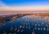 Aerial view of marina at sunset with many boats.