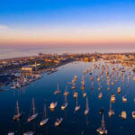 Aerial view of marina at sunset with many boats.
