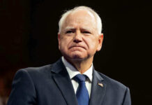 Tim Walz Just Pardoned WORST of the WORST Illegal Alien! Man in suit with a U.S. flag pin.