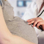 ALL Pregnant Travelers Will Need THIS For U.S Entry! Doctor uses stethoscope on pregnant womans belly.