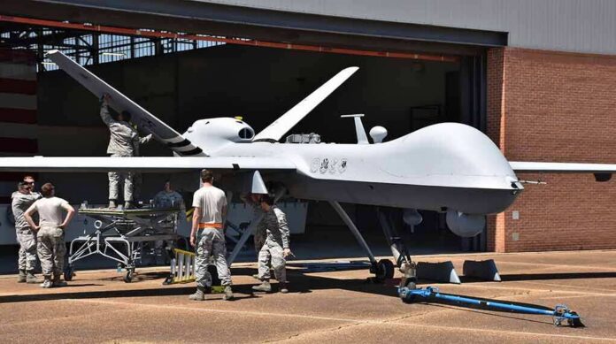 shutterstock_1079246960 Military drone being serviced by ground crew outside a hangar