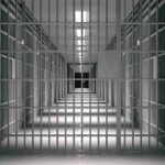 Migrants Account for Half of Prison Inmates! empty prison corridor with barred cells
