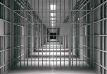empty prison corridor with barred cells