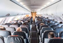 Airplane cabin with passengers seated in rows