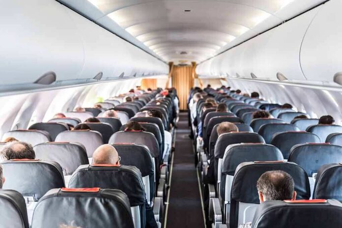 shutterstock_1155913306 Airplane cabin with passengers seated in rows