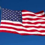 Dem Newest Star TRASHES U.S Flag During Campaign Rally Waving American flag against a clear blue sky