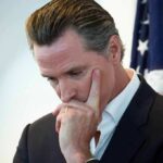 man in suit touching his face thoughtfully