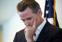man in suit touching his face thoughtfully