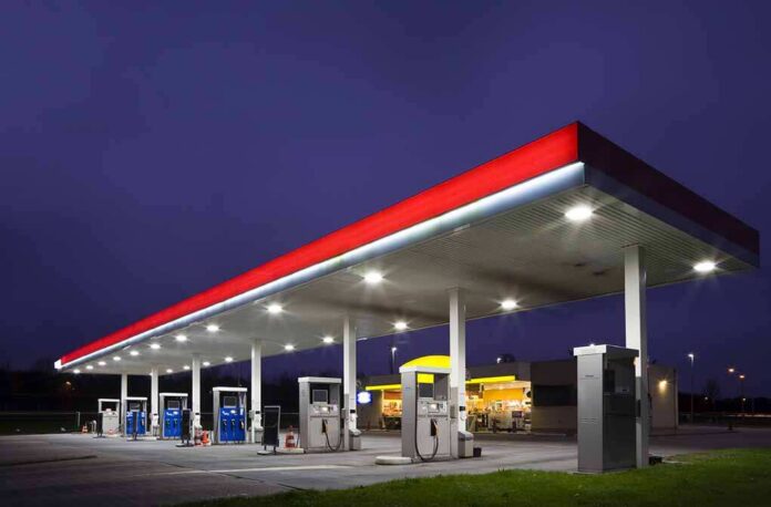 A gas station at night with illuminated fuel pumps and a convenience store