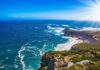 Rocky coastal cliffs with turquoise ocean and bright sun