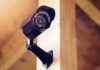 A security camera mounted on a wooden wall