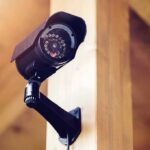 A security camera mounted on a wooden wall
