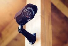 A security camera mounted on a wooden wall