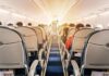 airplane cabin with passengers seated in economy class