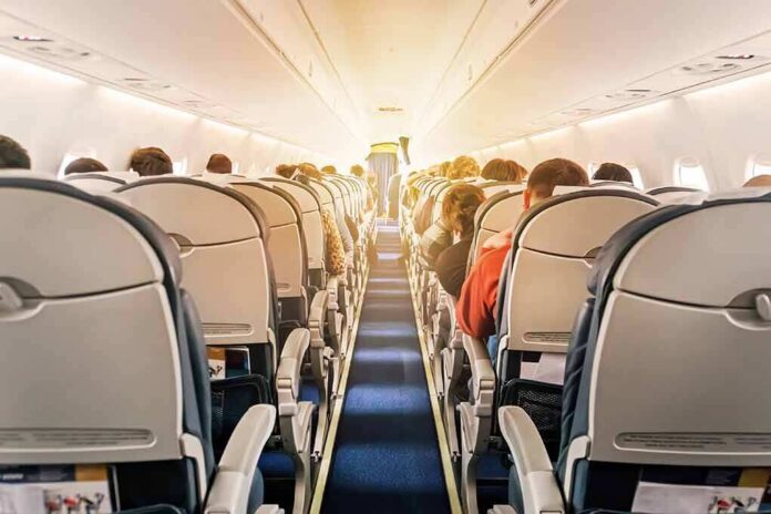 airplane cabin with passengers seated in economy class
