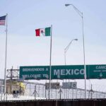 Border crossing with U.S. and Mexico flags and a sign welcoming to Mexico