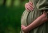 Birth Tourism Prevention Task Force LAUNCHES! Pregnant woman holding her belly in a green dress