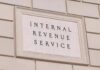Tax-The-Rich Crusader Hit With IRS Tab Internal Revenue Service building sign on a stone wall