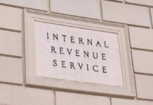Tax-The-Rich Crusader Hit With IRS Tab Internal Revenue Service building sign on a stone wall