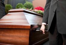 Pallbearer holding a wooden casket handle