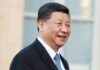 Humiliating: Trump Critics Go Wild as He Rolls Out Red Carpet for XI man in suit smiling outdoors