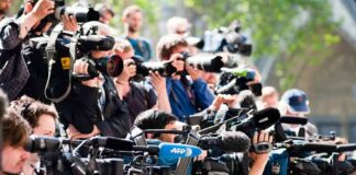 Group of news camera operators filming at an outdoor event