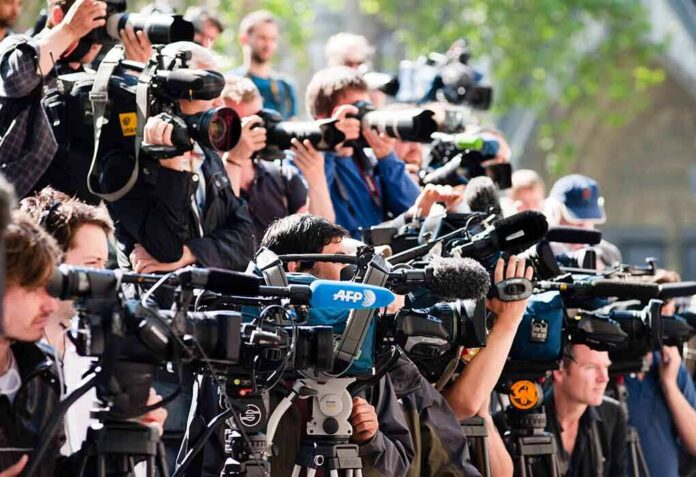 Group of news camera operators filming at an outdoor event