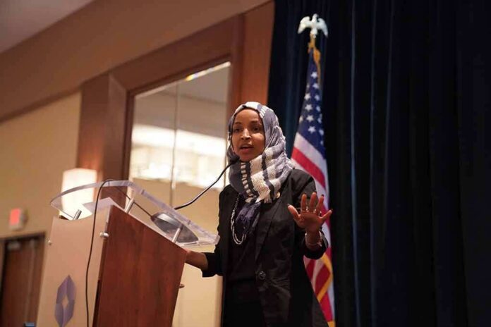 shutterstock_1397740550-1 Ilhan Omar speaking at a podium with a microphone