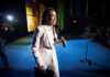 Woman in a light suit holding a microphone on a stage
