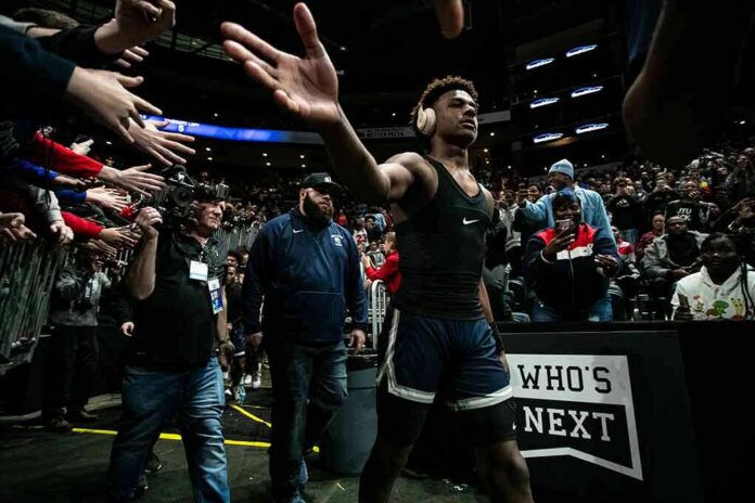 Basketball player in arena high-fives fans while wearing headphones