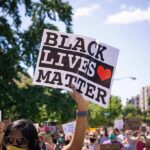 protester holding a Black Lives Matter sign at a daytime march