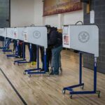 Voters at polling booths in a gymnasium