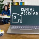 Laptop displaying rental assistance message on desk