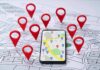 Travel App Outs NATO Homes Smartphone with map app surrounded by red location pins