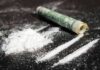 White powder and rolled bill on a dark surface
