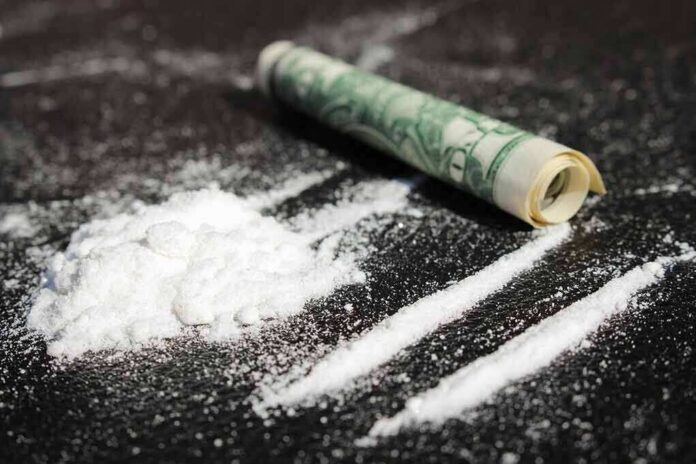 White powder and rolled bill on a dark surface