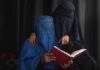 Shock Move to Ban Burkas in Schools Underway Two veiled women reading a red book together
