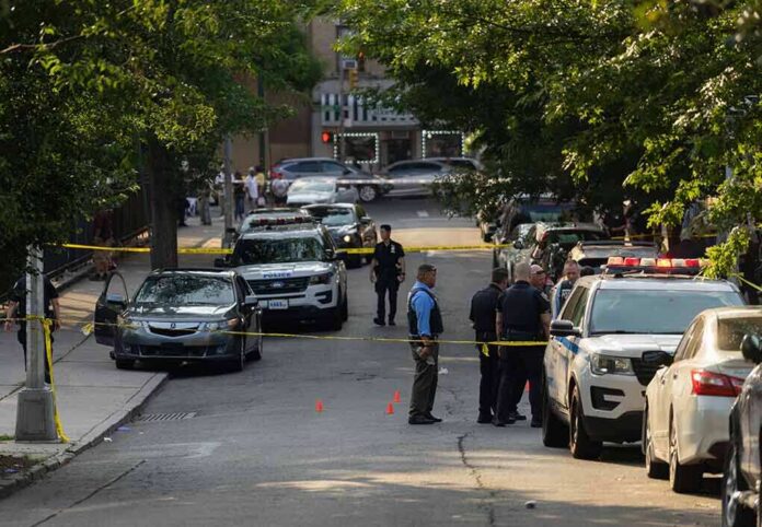 shutterstock_2330301305-4 Police officers secure a residential street with patrol cars and yellow tape