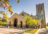 Bulldozers Flatten 156-Year Landmark Brick church with arched entrance and tall bell tower on a sunny day