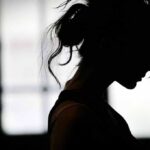silhouette of a woman in profile against a bright window
