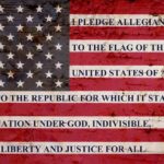 American flag with pledge text on a weathered surface