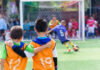 Two boys watching a soccer game together.