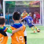 Two boys watching a soccer game together.